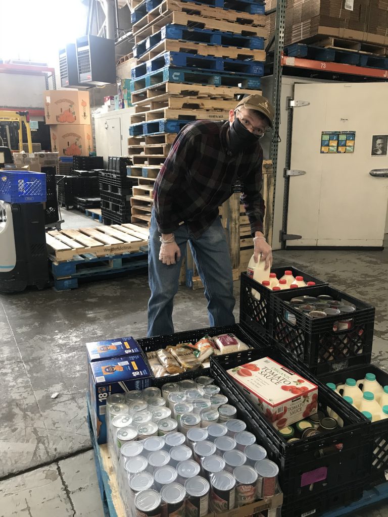 Elder Hunt helps pack food for clients at the Storehouse. He volunteers several times a week as part of his service mission with the Church of Jesus Christ of Latter-day Saints 