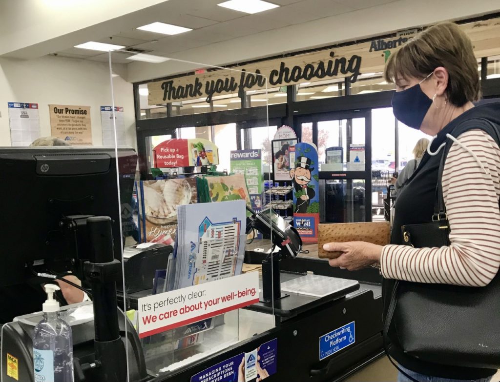 woman pays at the Albertsons Market checkout
