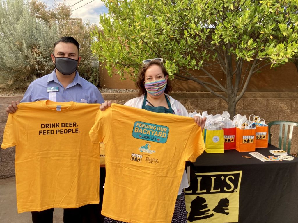 Storehouse board member and staff holding Feeding Our Backyard t-shirts 