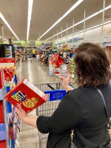 shopper comparing products to save money as food prices rise.