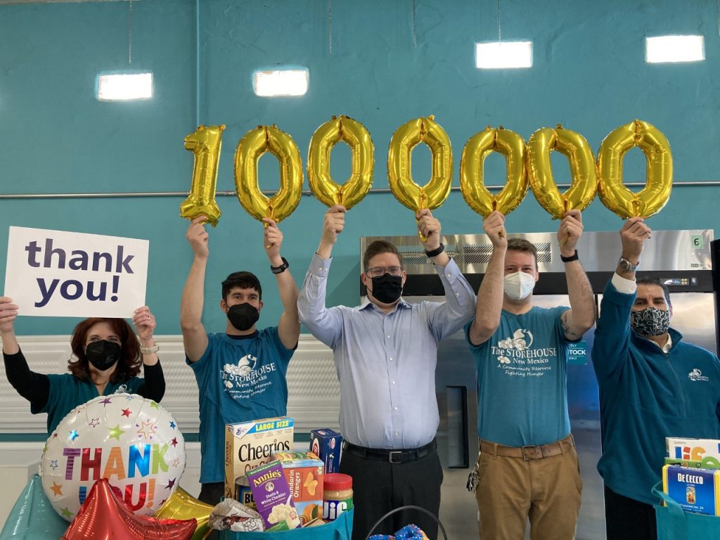 Storehouse and Sandia Area teams hold up balloons for 1,000,000 meals and thank you signs