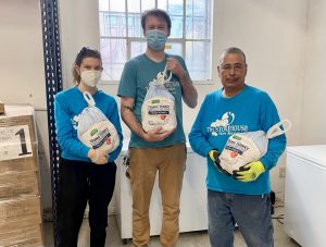 three storehouse new mexico staff members holding thanksgiving turkeys