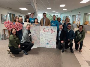 Sandia Area team members with giant thank you card from the Storehouse