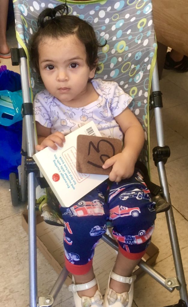 A toddler sitting in a baby stroller at the Storehouse food pantry